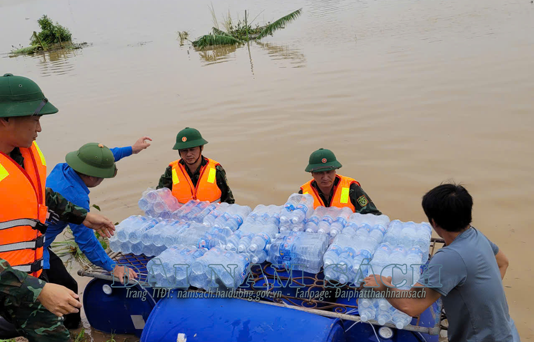 cán bộ, chiến sĩ BCHQS huyện hỗ trợ vận chuyển nhu yếu phẩm vào cho nhân dân thôn Lấu Khê.jpg.png